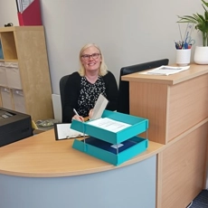 Eileen sitting at her desk)